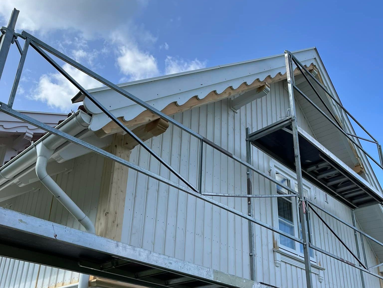 Hvitt hus under oppussing med stillas